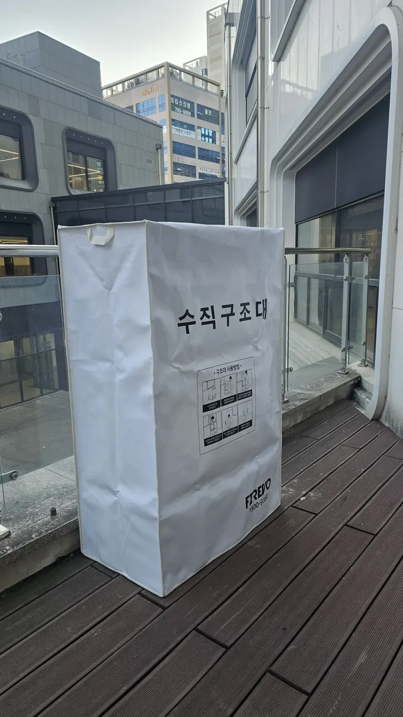 건물 내부 벽면에 설치된 흰색 수직구조대 보관함